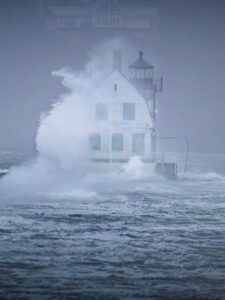 A Very large waves crashes over top of the Rockland Breakwater Lighthouse.
