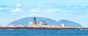 Cadillac Mountain rises behind Mount Desert Rock Lighthouse.