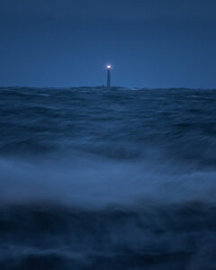 Boon Island Lighthouse shining over a stormy sea.